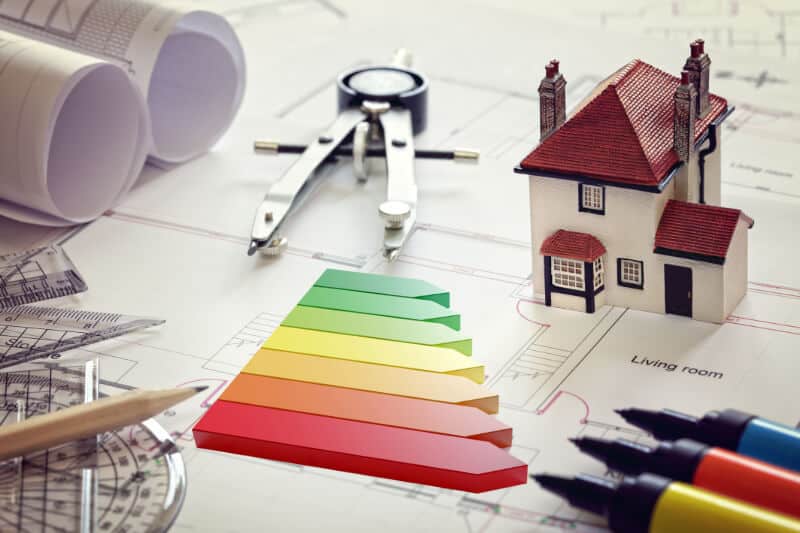 Haus und Zirkel als Symbolik für Sanierungsplanung als wichtiger Bestandteil einer Gebäudeenergieberatung